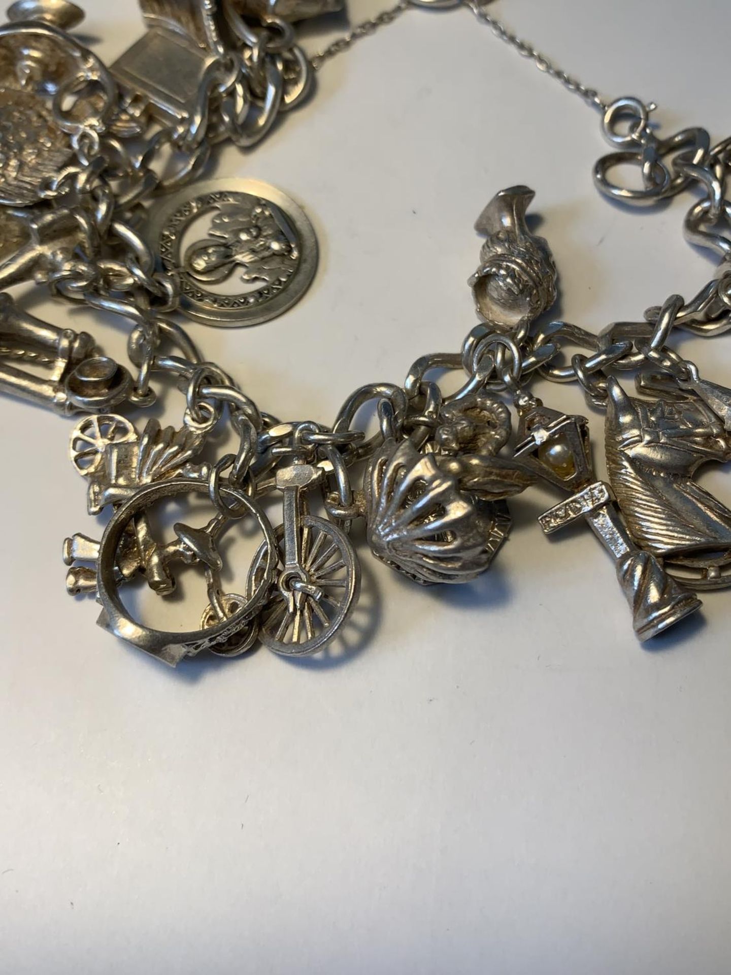 A SILVER CHARM BRACELET WITH TWENTY CHARMS AND A HALLMARKED LONDON SILVER HEART CLASP - Image 3 of 5