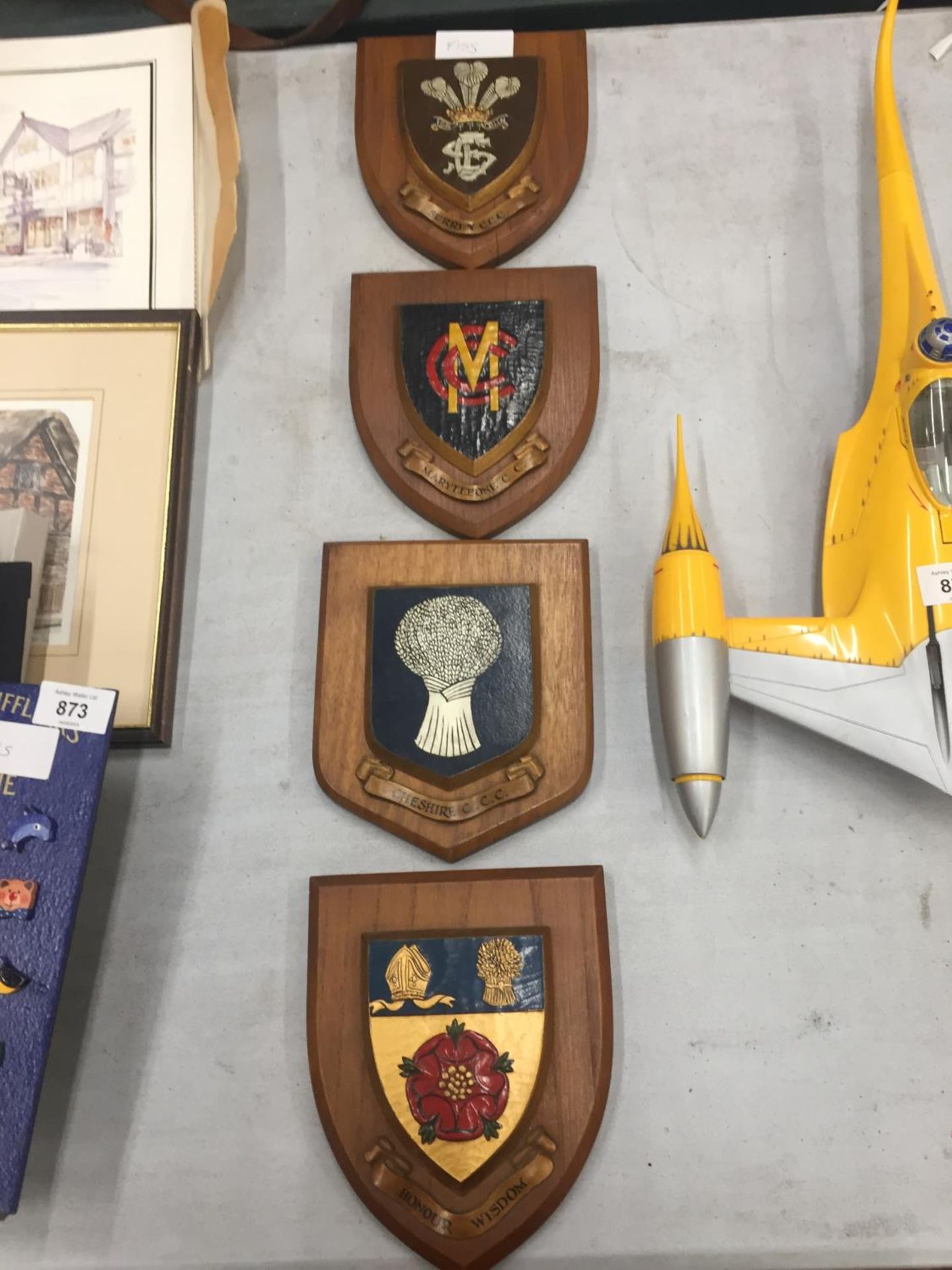 FOUR SHIELDS ON WOODEN PLAQUES TO INCLUDE CHESHIRE CCC, MARYLEBONE CCC, ETC