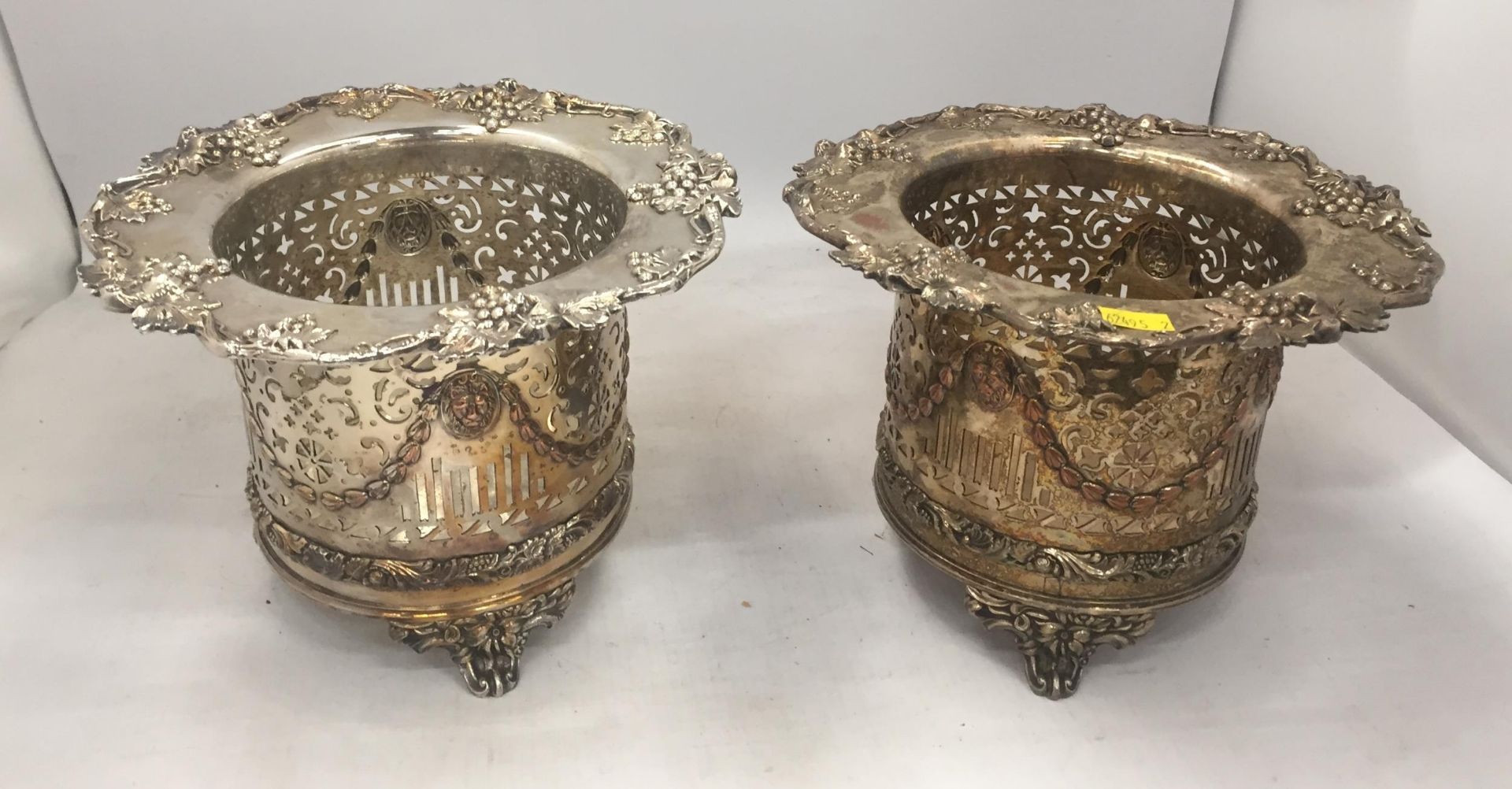 A PAIR OF EARLY 20TH CENTURY WINE BOTTLE HOLDERS WITH FLORAL AND PIERCED DESIGN