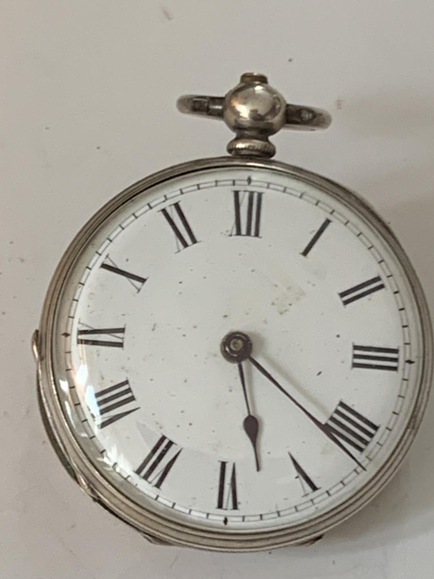 A MARKED FINE SILVER POCKET WATCH WITH WHITE ENAMEL FACE AND ROMAN NUMERALS