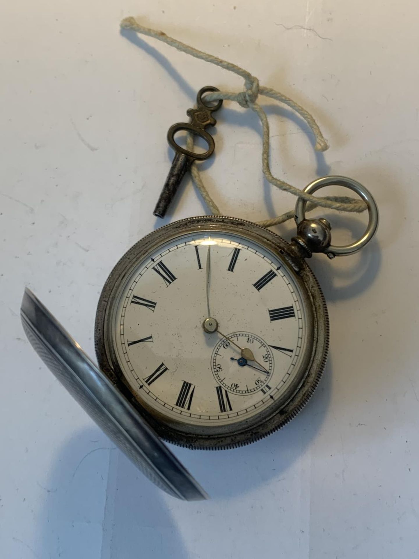 A MARKED 800 SILVER POCKET WATCH WITH WHITE ENAMEL FACE, ROMAN NUMERALS, SUB DIAL AND KEY