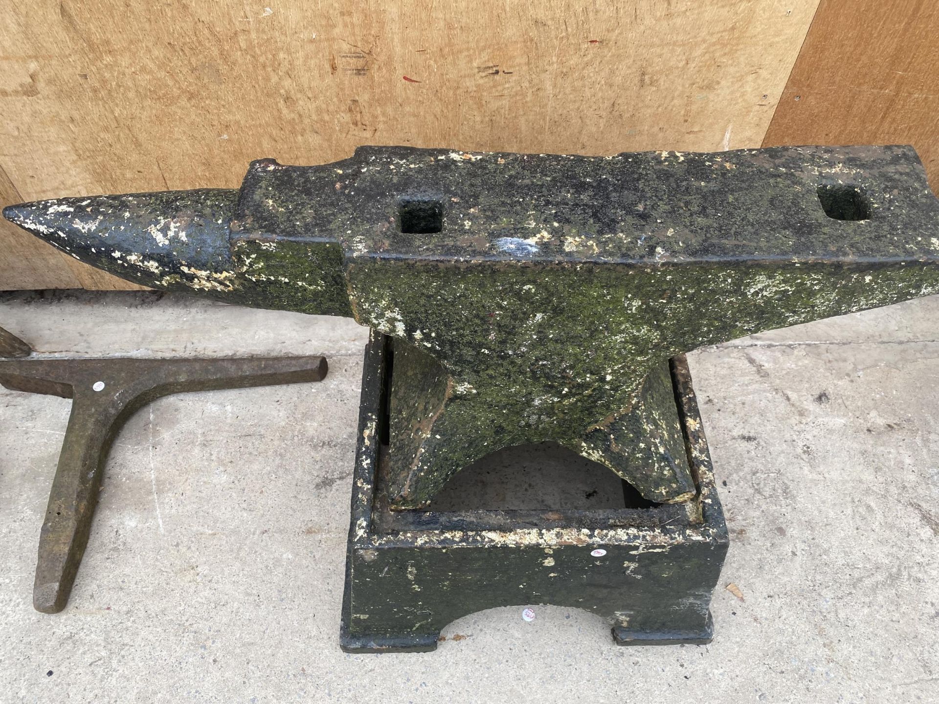 A LARGE VINTAGE CAST IRON BLACKSMITHS ANVIL WITH CAST IRON STAND (ANVIL H:36CM L:96CM STAND H:31CM)