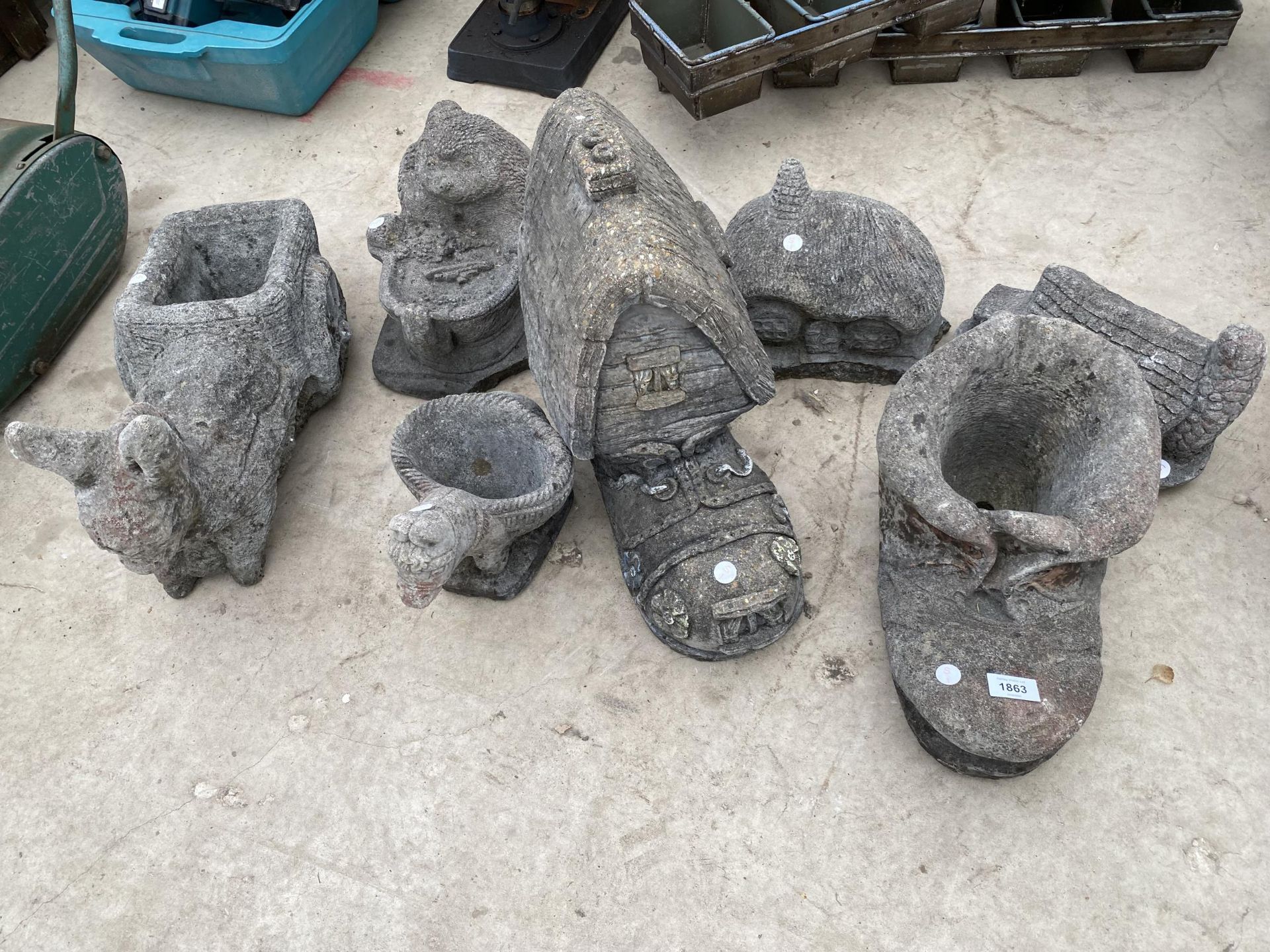 AN ASSORTMENT OF RECONSTITUTED STONE GARDEN ORNAMENTS TO INCLUDE BOOTS, COTTAGES AND PLANTERS ETC