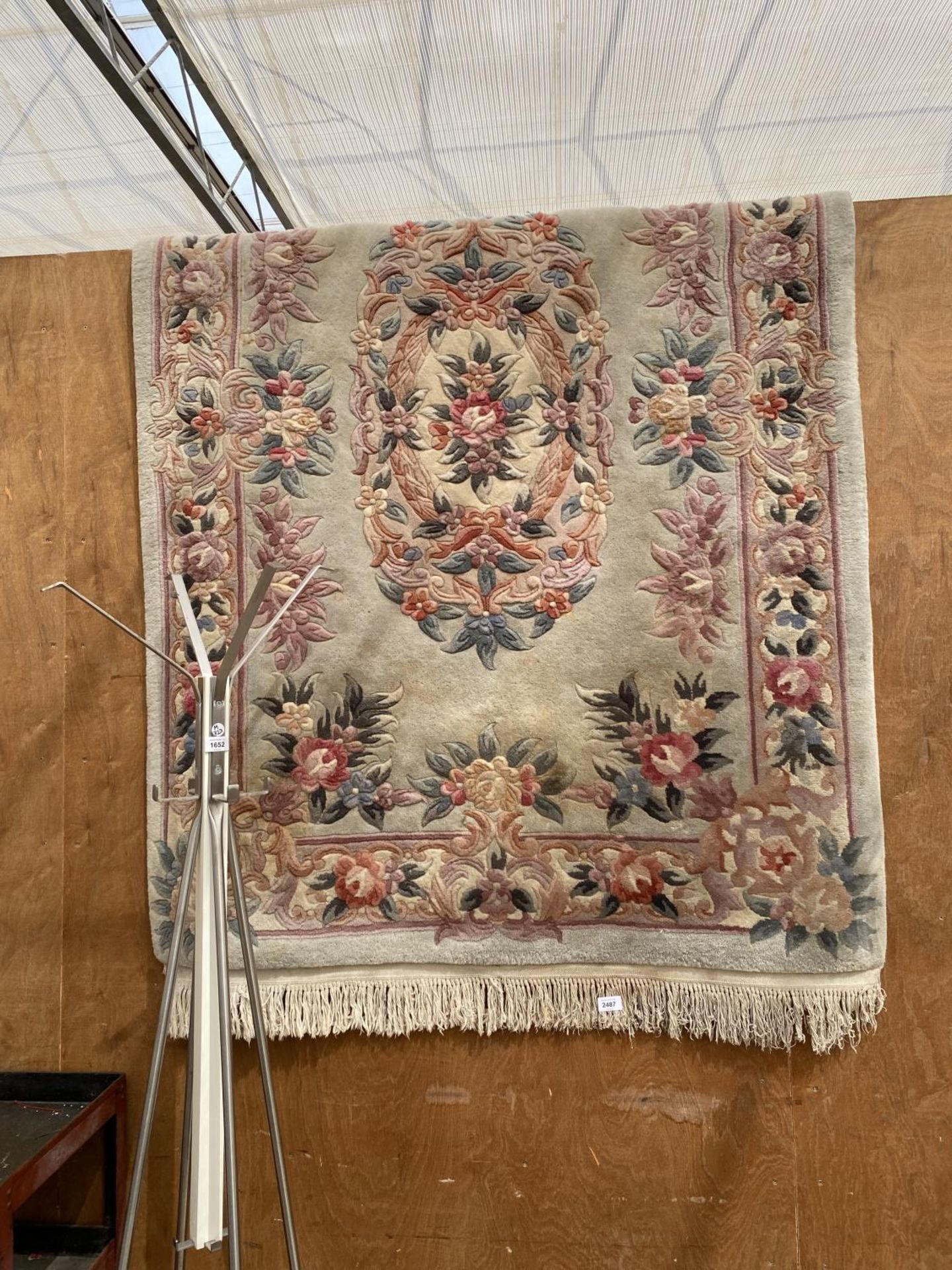 A CREAM PATTERNED FRINGED RUG