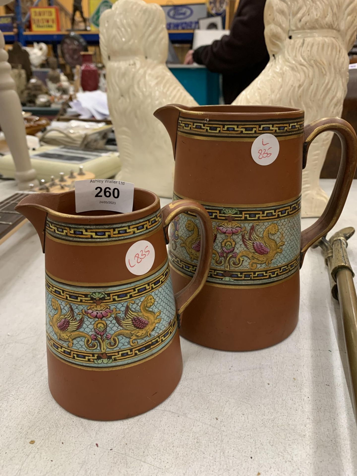 TWO TERRACOTTA TYPE VASES WITH GRIFFIN DESIGN BANDING