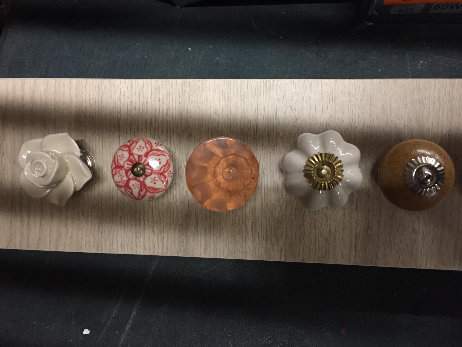 A COLLECTION OF MODERN DRAWER KNOB SAMPLES ON A WOODEN BACK - Image 2 of 3