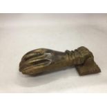 A HEAVY VINTAGE BRASS DOOR KNOCKER IN THE SHAPE OF A HAND