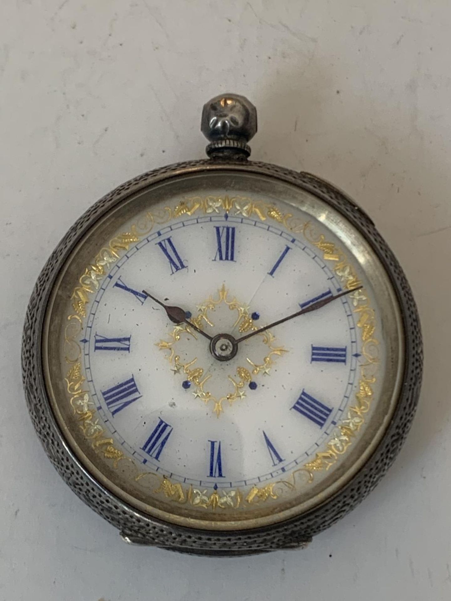 A MARKED 935 SILVER POCKET WATCH WITH WHITE ENAMEL AND FLORAL DECORATION FACE AND ROMAN NUMERALS (