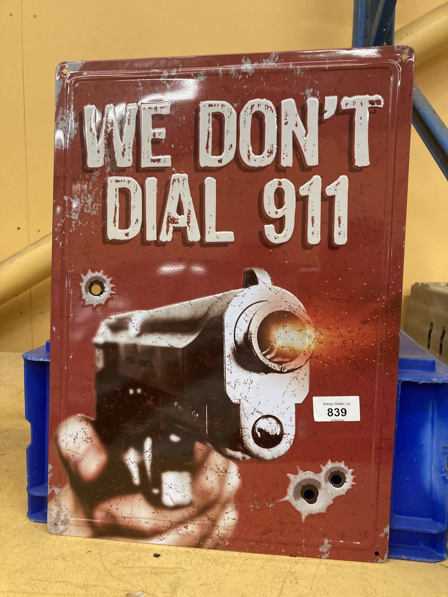 A TIN PLATE SIGN 'WE DON'T DIAL 911' 42.5CM X 30.5CM