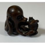 AN ORIENTAL NETSUKE OF AN OCTUPUS AND FISH, SIGNED WITH MOTHER OF PEARL MAKERS MARK, HEIGHT 3.5CM