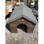 A WOODEN AND FELT ROOF DOG HOUSE
