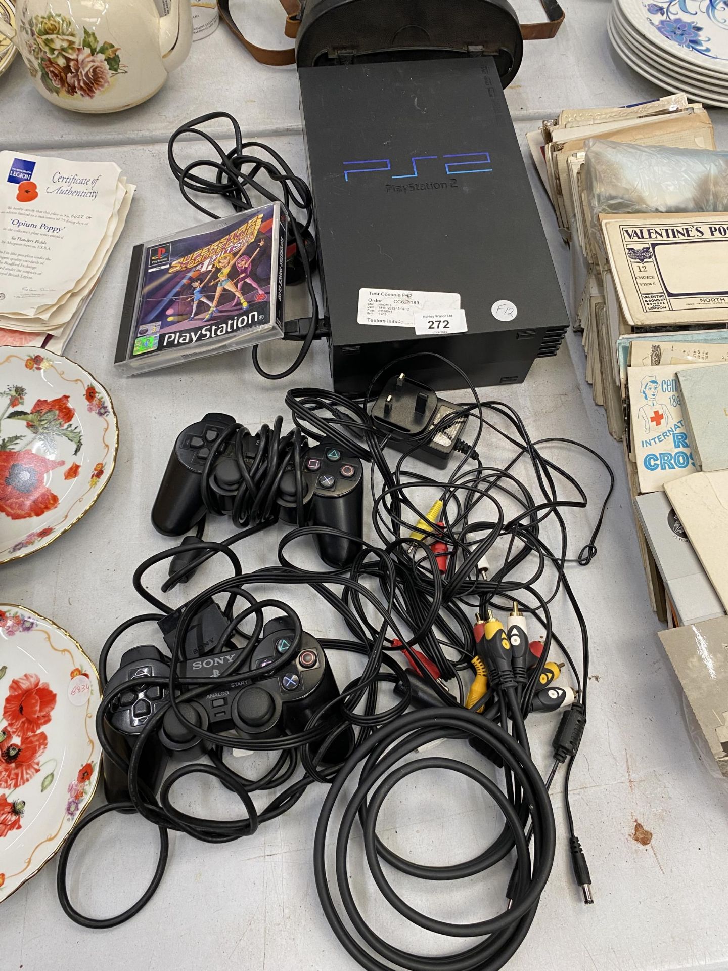 A PS2 WITH TWO CONTROLLERS, CABLE AND A SUPERSTAR DANCE CLUB GAME