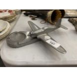 A WHITE METAL MODEL OF A PLANE WITH A PLINTH