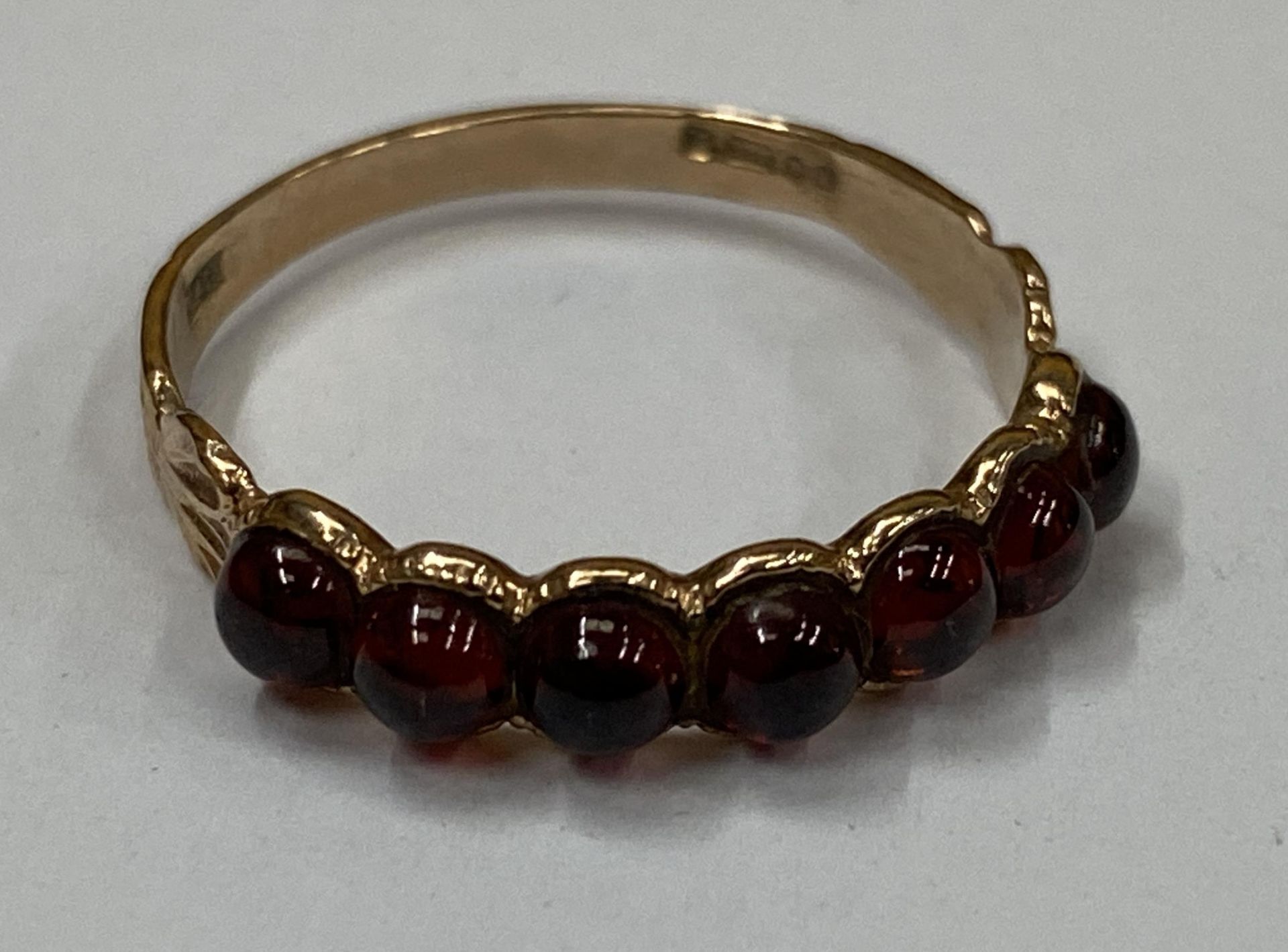 A 9CT YELLOW GOLD WITH SEVEN GARNET SET STONES, WEIGHT 1.63G