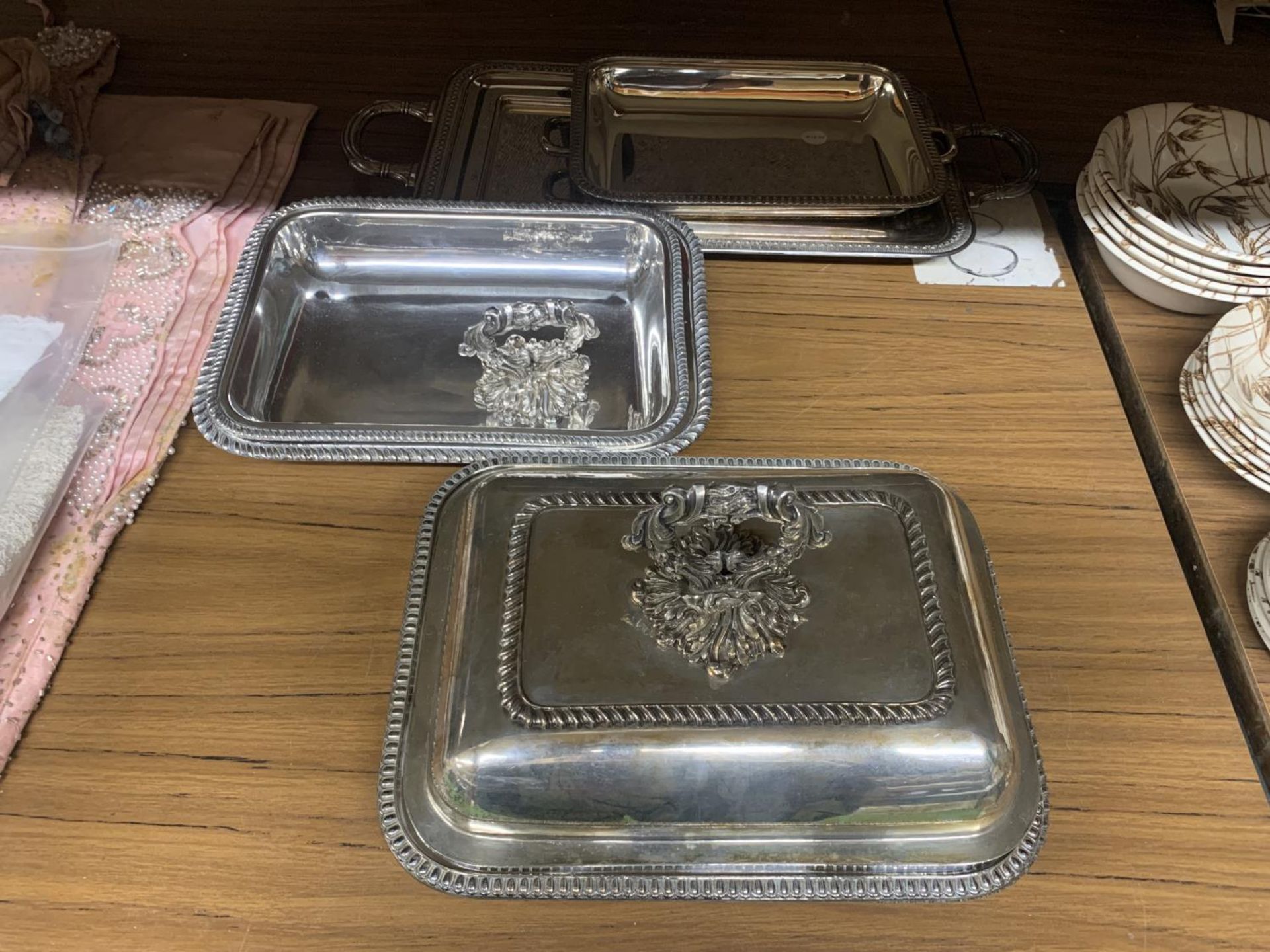 TWO SILVER PLATED HANDLED SERVING TRAYS PLUS FOUR SERVING DISHES, ONE WITH LID