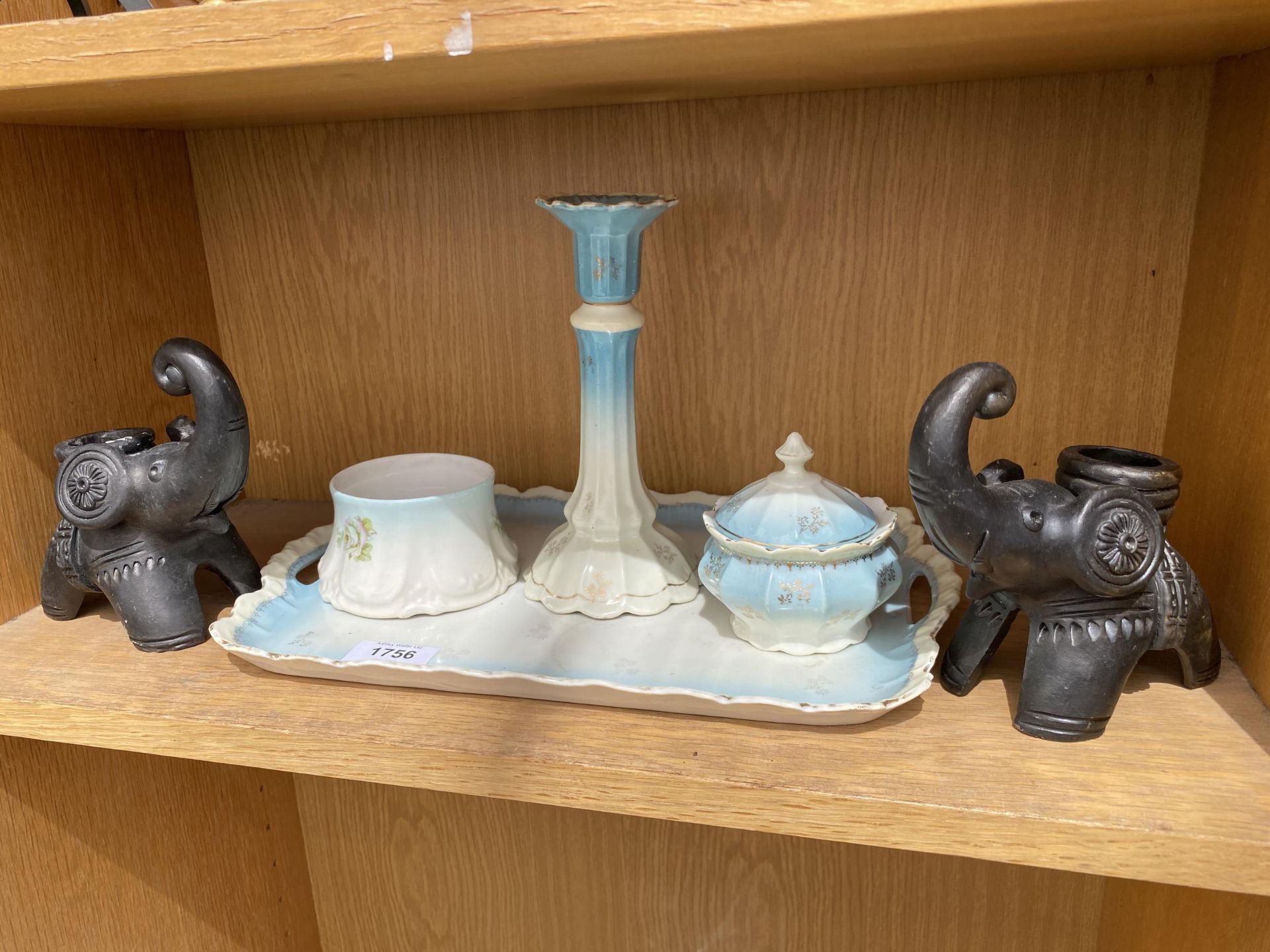 A CERAMIC DRESSING TABLE SET AND TWO TREEN ELEPHANT CANDLE STICKS