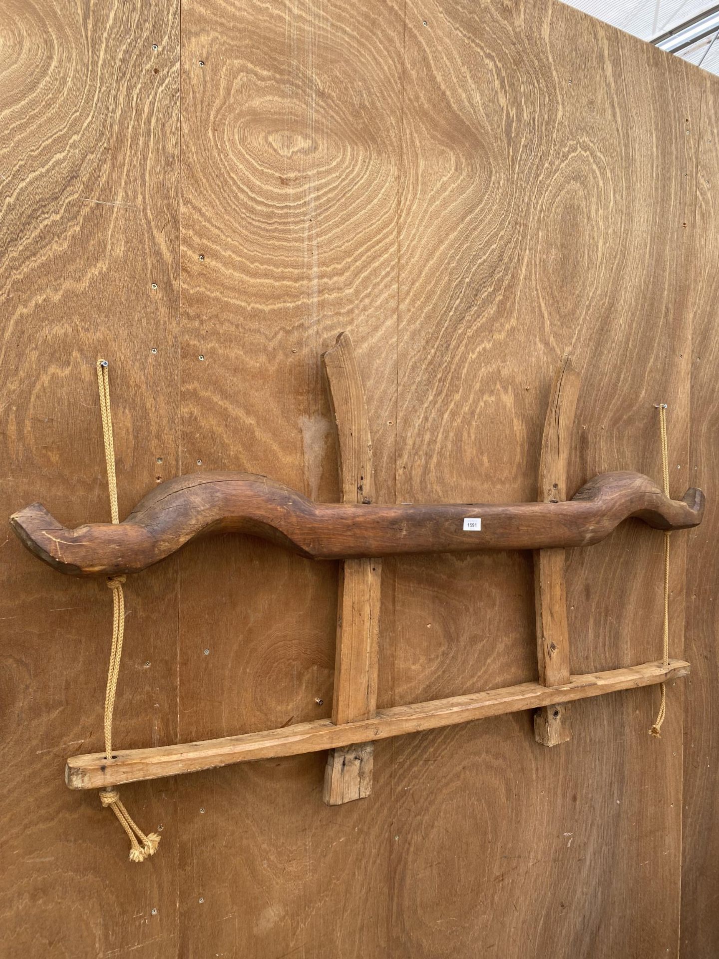 A VINTAGE WALL SHELF CREATED USING A WOODEN YOKE