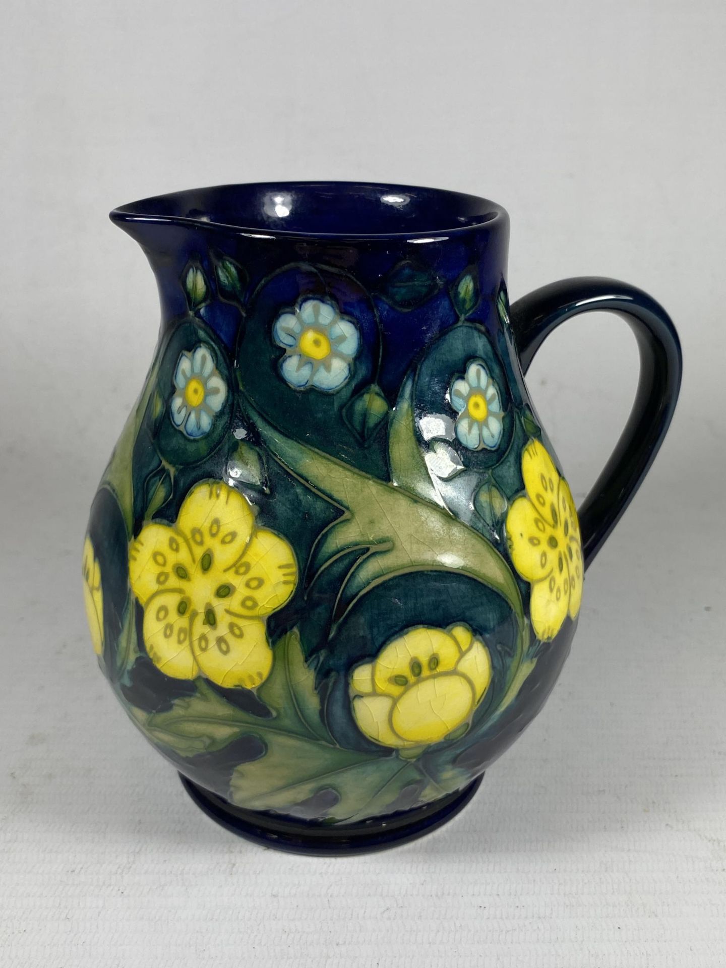 A MOORCROFT POTTERY BUTTERCUP PATTERN JUG BY SALLY TUFFIN
