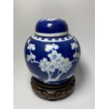 A CHINESE PRUNUS BLOSSOM PATTERN GINGER JAR ON CARVED WOODEN STAND, DOUBLE RING MARK TO BASE, HEIGHT