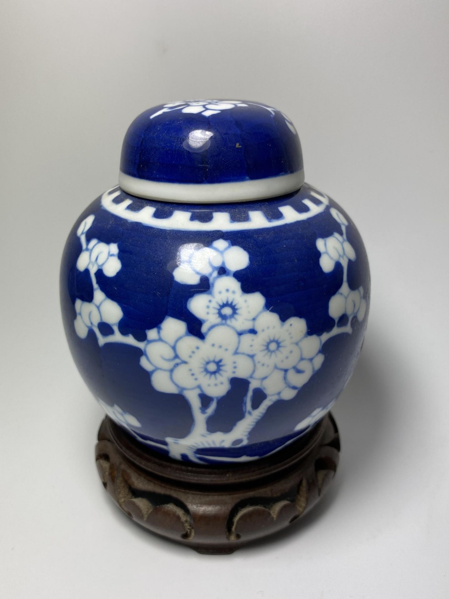 A CHINESE PRUNUS BLOSSOM PATTERN GINGER JAR ON CARVED WOODEN STAND, DOUBLE RING MARK TO BASE, HEIGHT