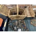 A WICKER BASKET CONTAINING A QUANTITY OF VINTAGE TOOLS TO INCLUDE WOODEN MALLETS, PLANES, A LAMP,