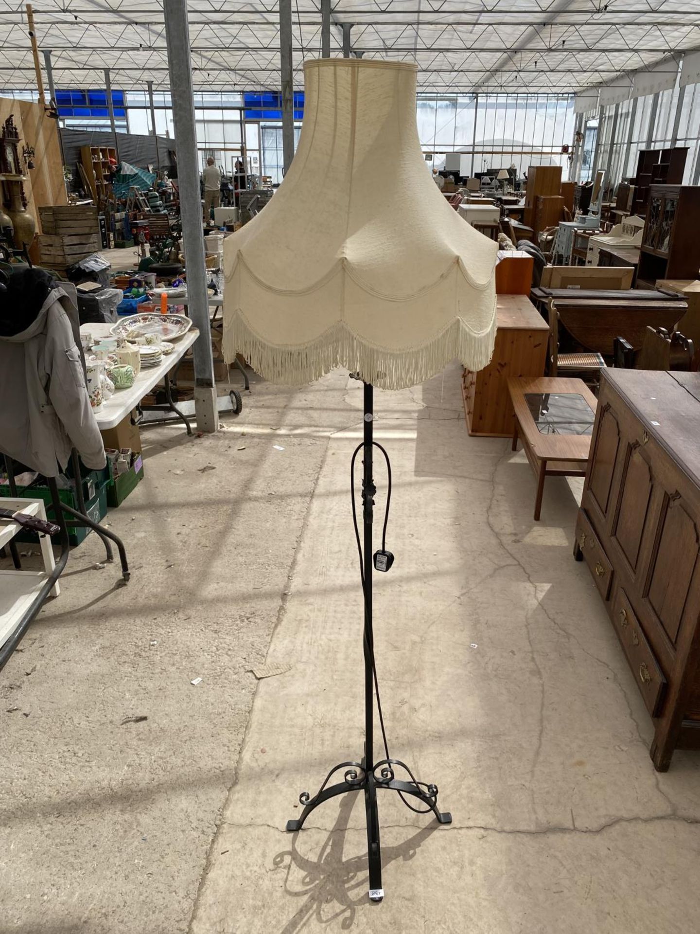 A WROUGHT IRON STANDARD LAMP COMPLETE WITH SHADE