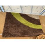 A MODERN GREEN AND BROWN RUG