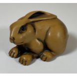 AN ORIENTAL NETSUKE OF A RABBIT, SIGNED WITH BONE INSET MAKERS PLAQUE, LENGTH 5CM