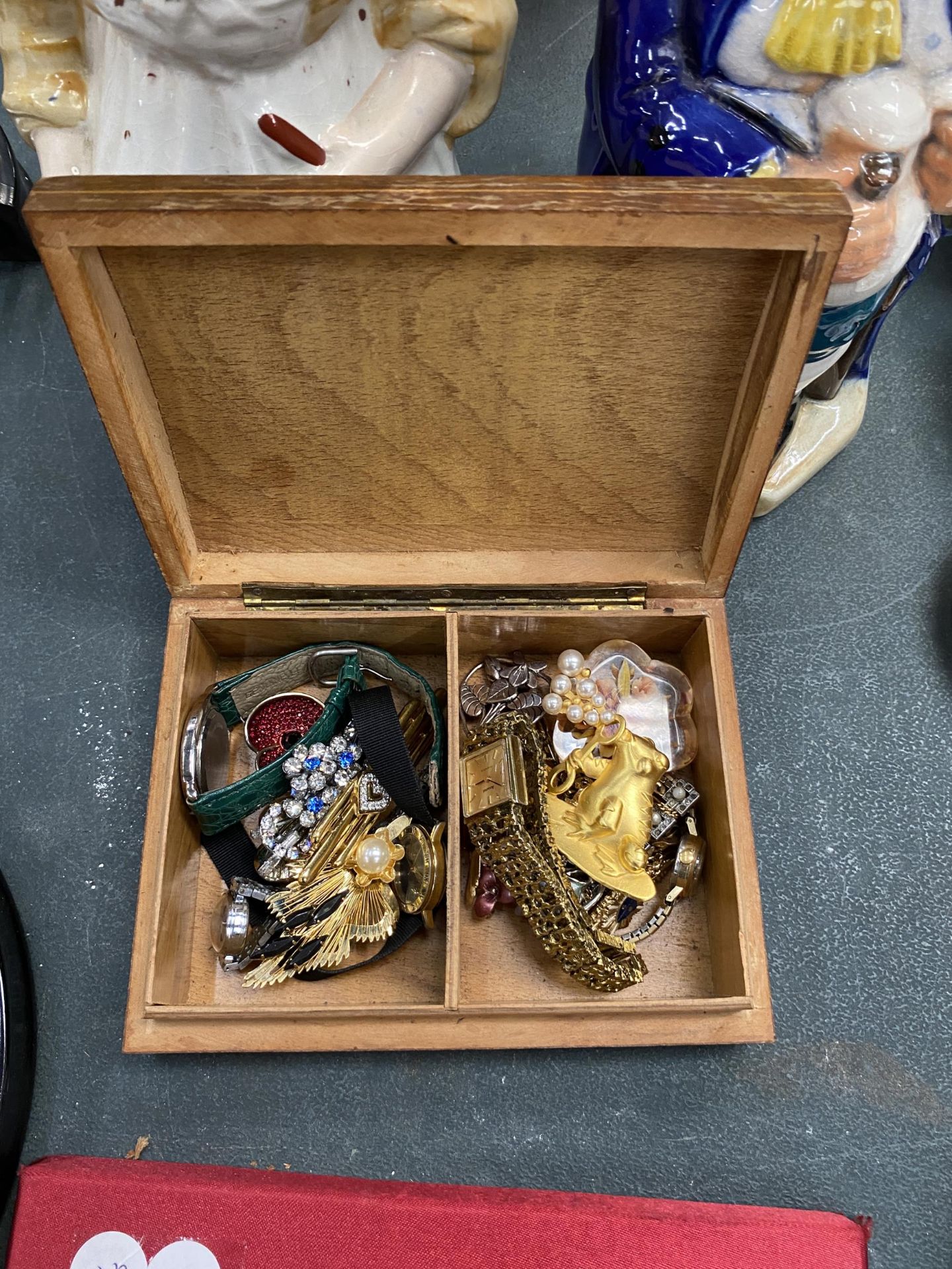 AN INLAID BOX CONTAINING A QUANTITY OF COSTUME JEWELLERY TO INCLUDE BROOCHES AND WATCHES