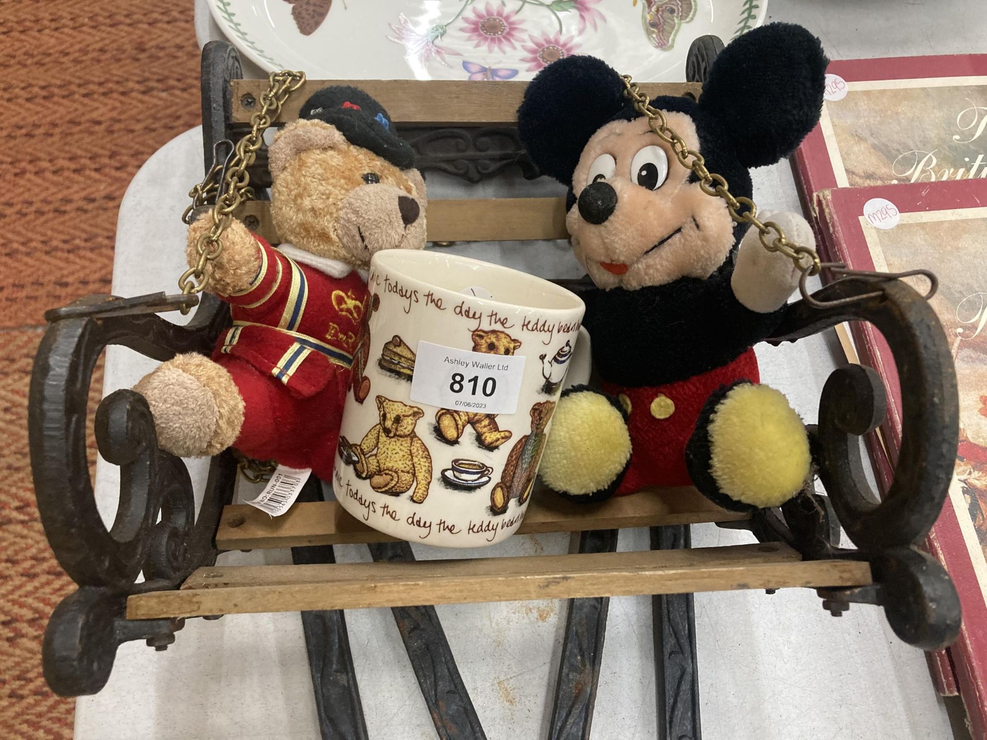 A CAST VINTAGE SMALL SWINGING SEAT WITH STAND PLUS MICKEY MOUSE AND TEDDY PLUSH FIGURES AND A MUG