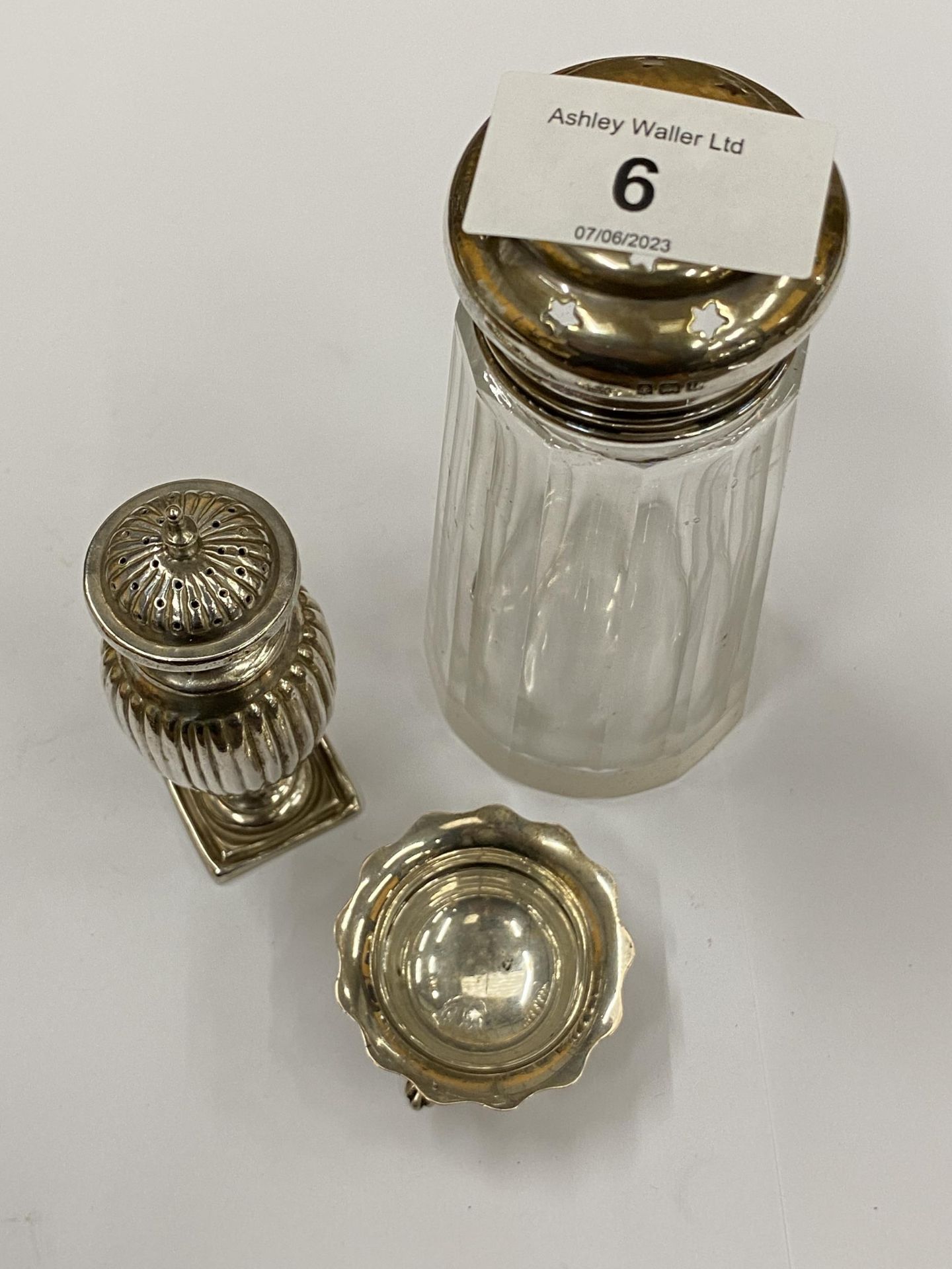 THREE SILVER ITEMS - HALLMARKED PEPPERETTE, OPEN SALT AND SILVER TOPPED SUGAR SIFTER