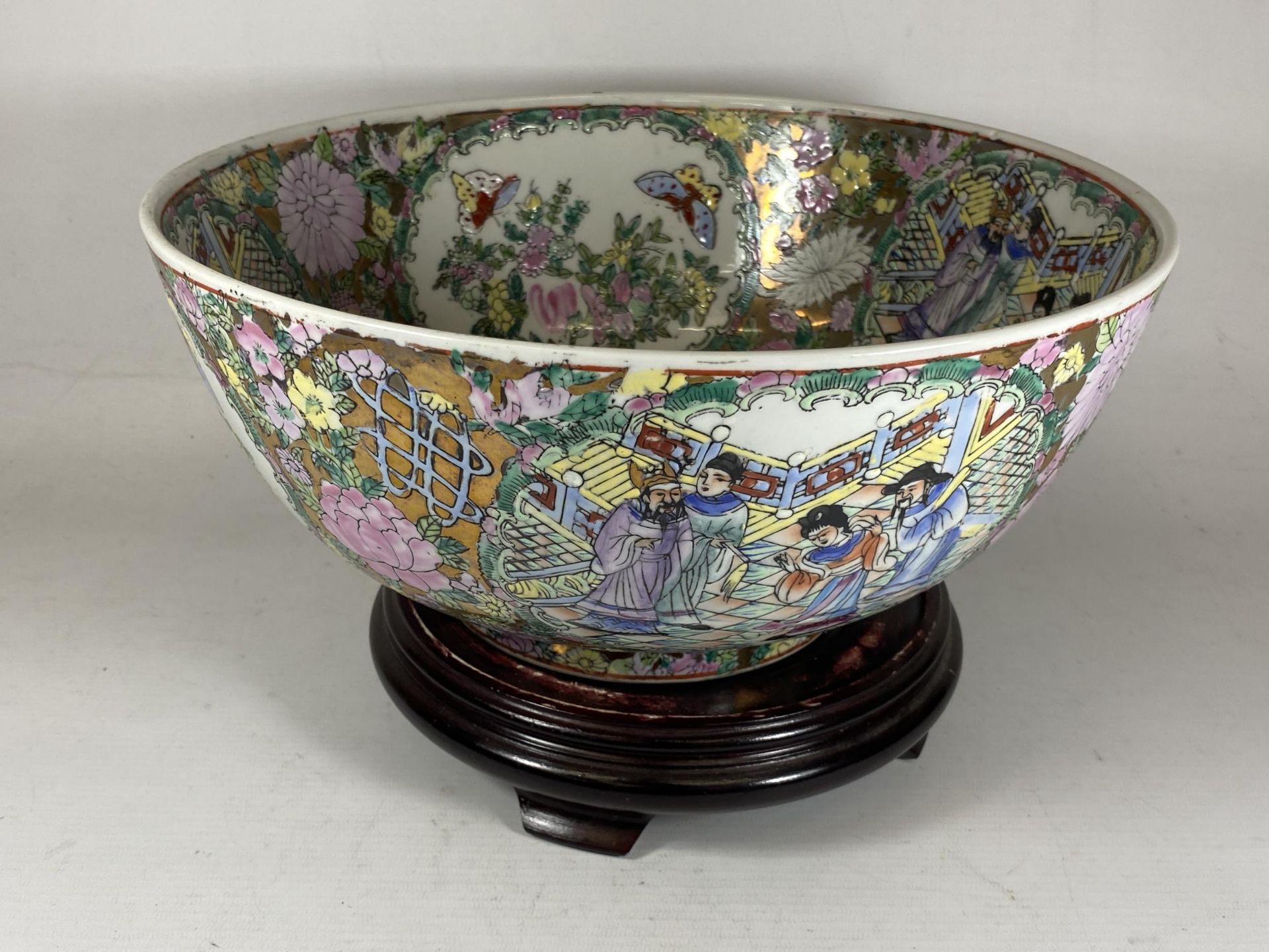 A LARGE CHINESE CANTON FAMILLE ROSE PUNCH BOWL DECORATED WITH ENAMELLED FIGURAL DESIGN ON A TURNED