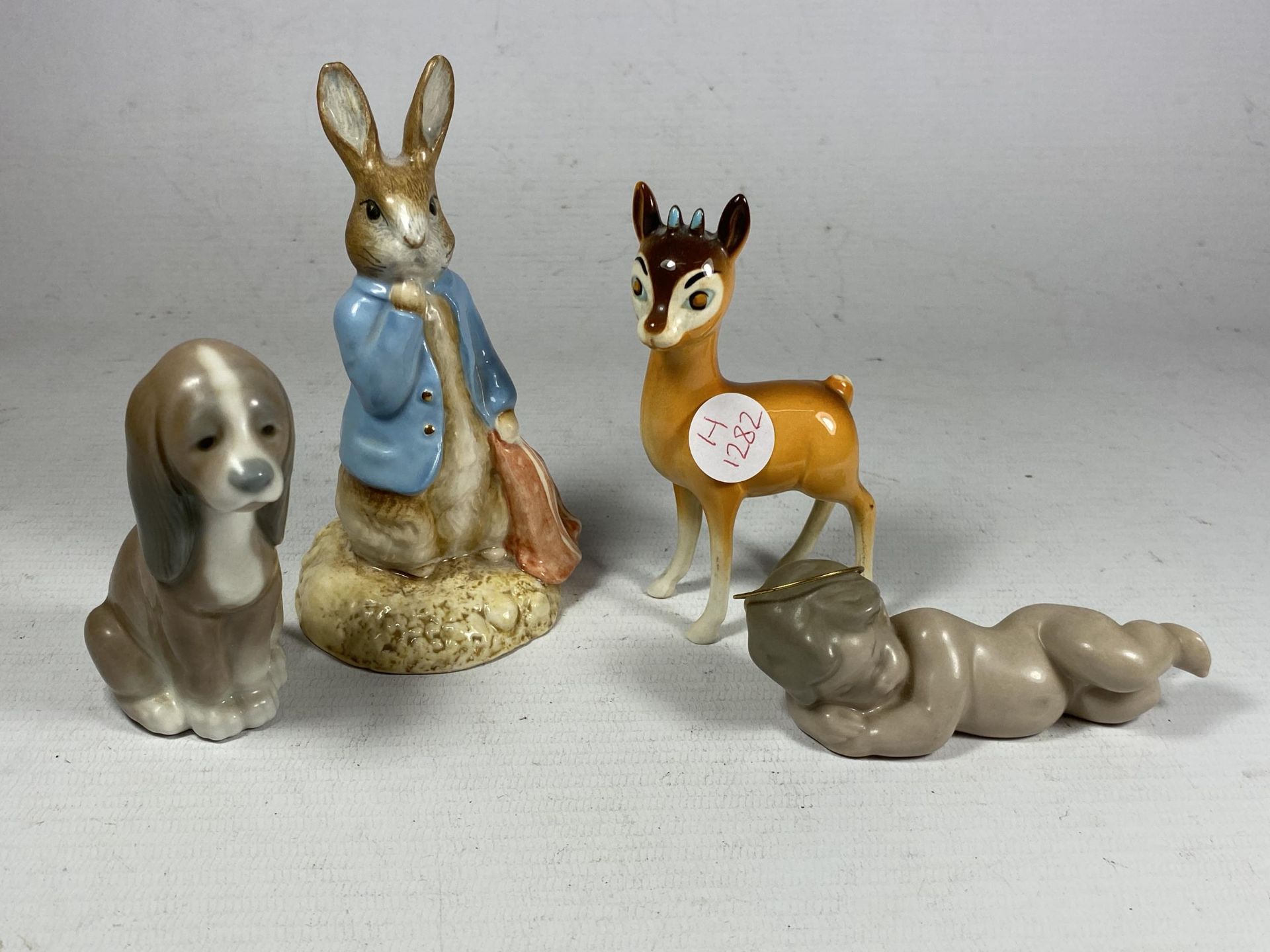 A GROUP OF FOUR CERAMIC FIGURES - LLADRO CHERUB AND DOG, BESWICK BAMBI AND BESWICK BEATRIX POTTER