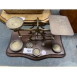 A SET OF VINTAGE WOOD AND BRASS POST OFFICE SCALES TO INCLUDE WEIGHTS