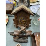 A WOODEN CUCKOO CLOCK COMPLETE WITH PENDULUM AND WEIGHTS