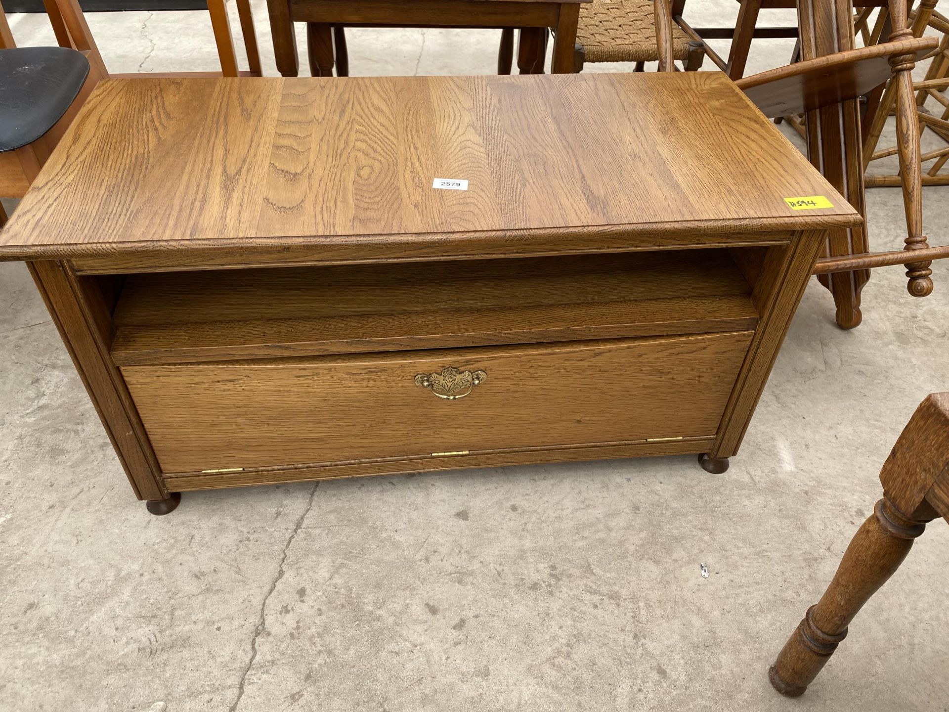 AN OAK TV STAND WITH DROP DOWN FRONT, 34" WIDE