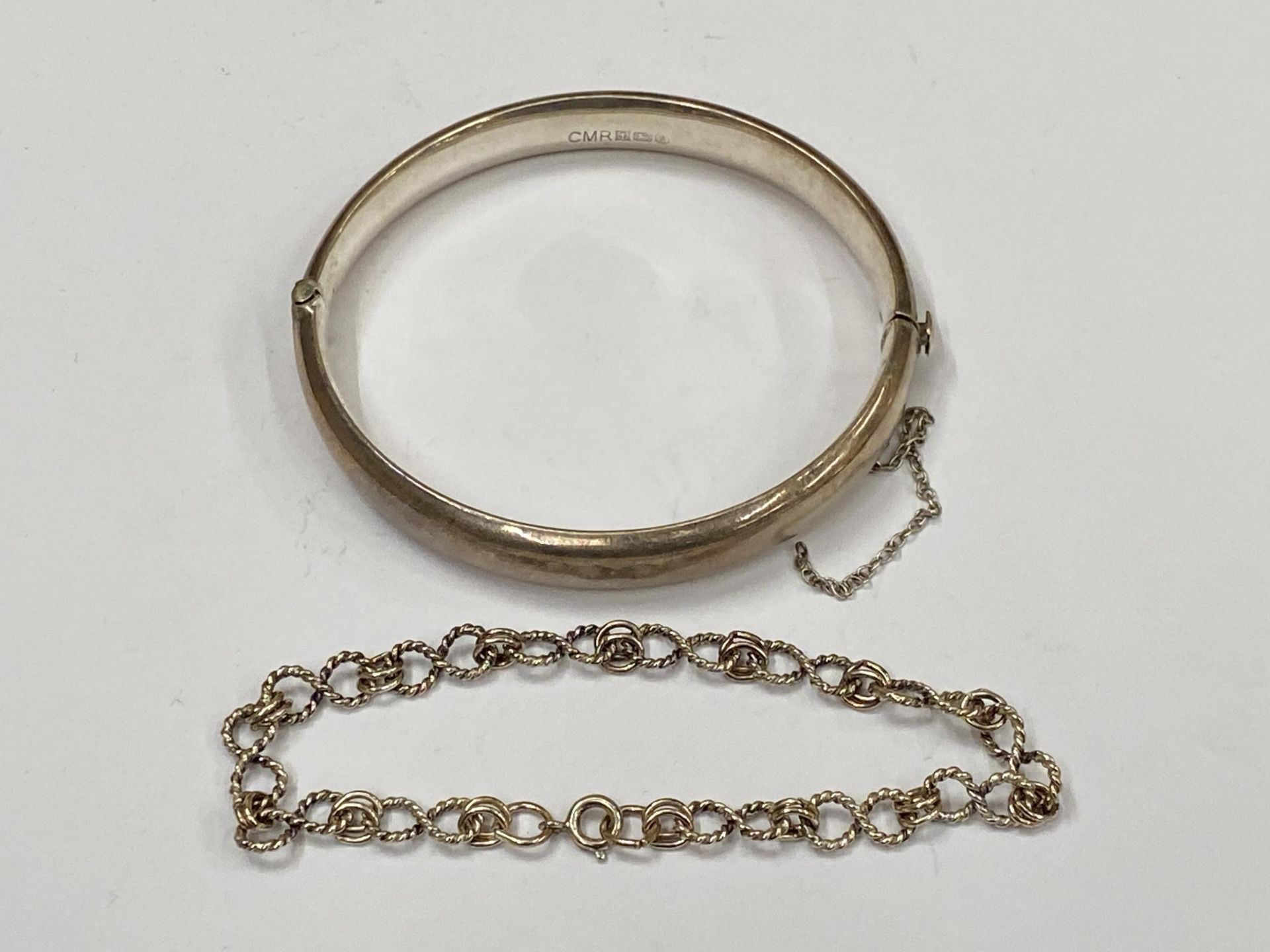 TWO SILVER BRACELETS TO INCLUDE HALLMARKED CHILD'S BANGLE AND OTHER DECORATIVE EXAMPLE