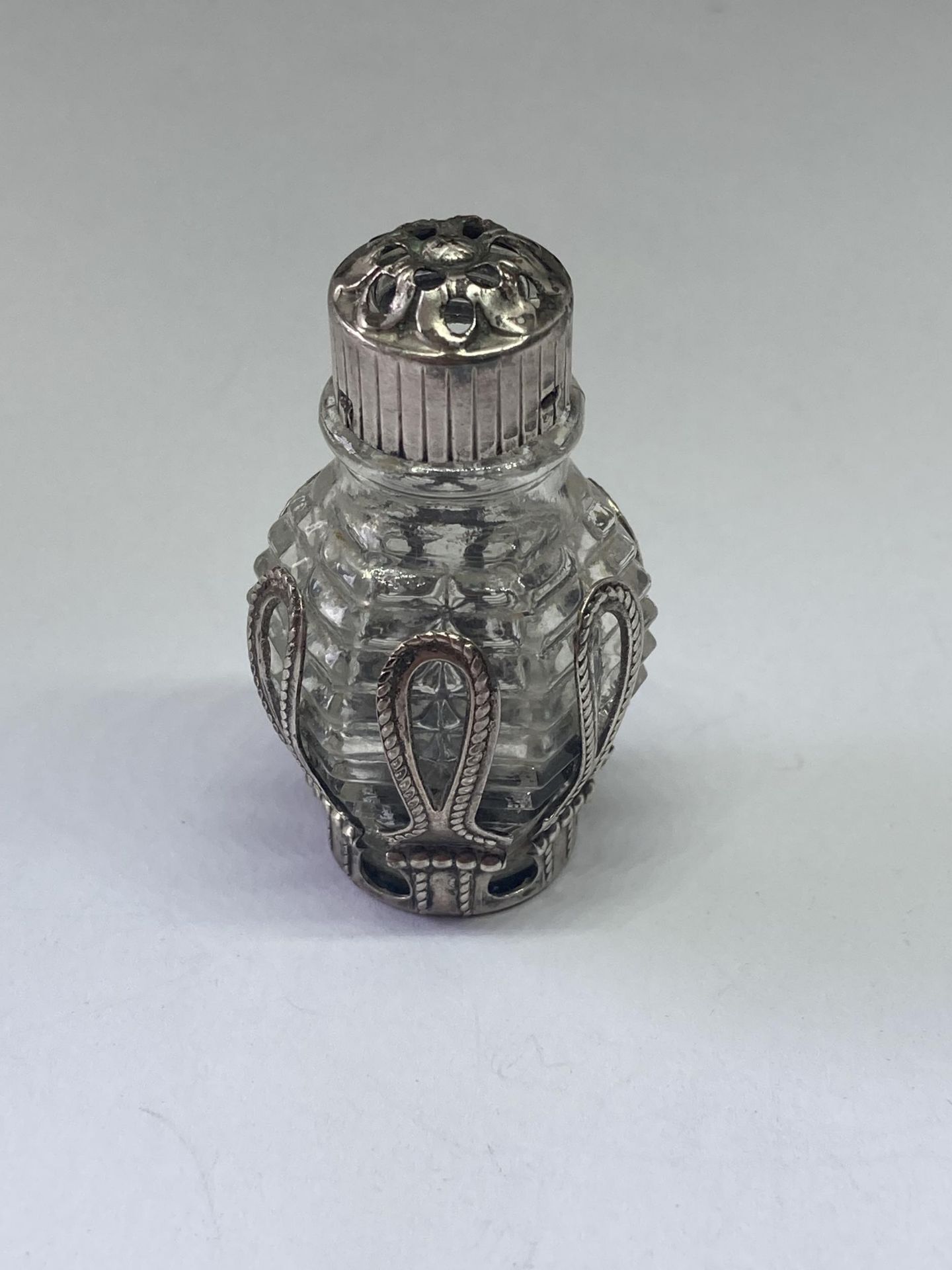 A SMALLGLASS AND METAL PERFUME BOTTLE