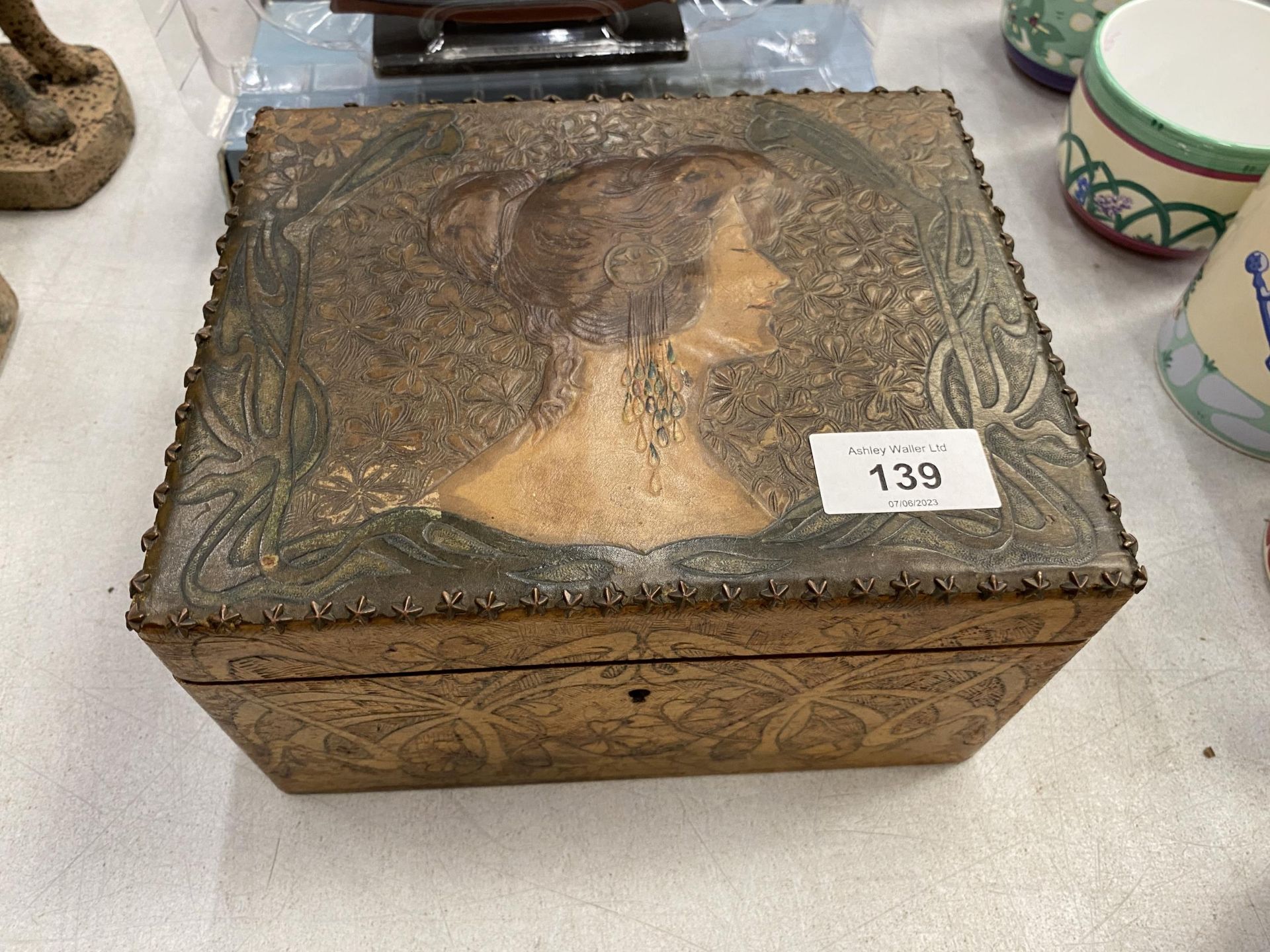 A WOODEN AND LEATHER BOX EMBOSSED WITH A LADY'S HEAD