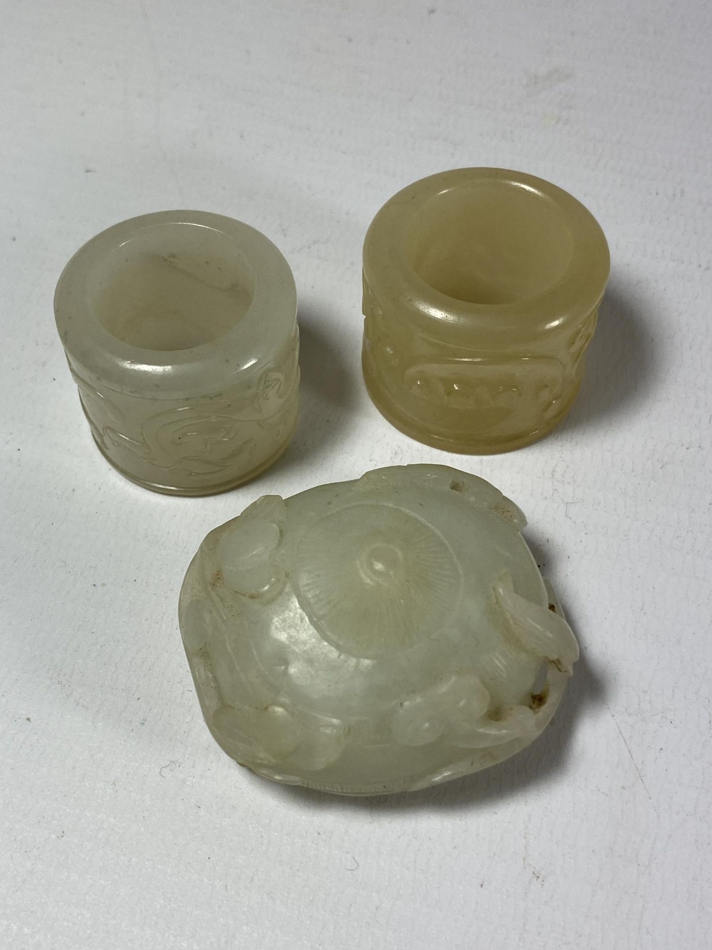 A GROUP OF THREE CHINESE JADE TYPE ITEMS, CARVED THUMB RINGS AND STONE