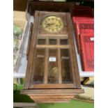 A VINTAGE MAHOGANY CASED WALL CLOCK WITH BEVELLED GLASS TO THE FRONT, COMPLETE WITH PENDULUM AND