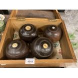 A VINTAGE PINE BOX CONTAINING FOUR BOWLING BOWLS