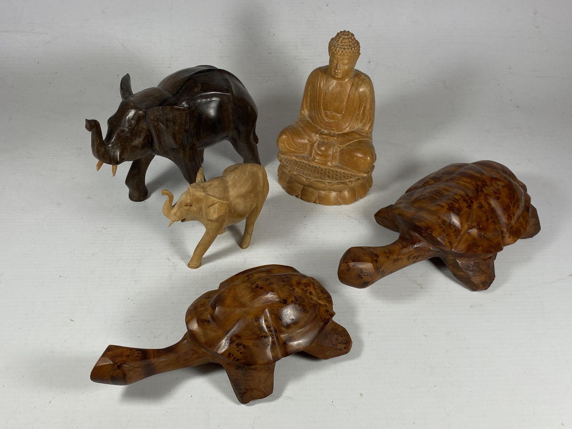 A GROUP OF ORIENTAL CARVED WOODEN FIGURES, SEATED BUDDHA, TURTLES AND TWO ELEPHANTS