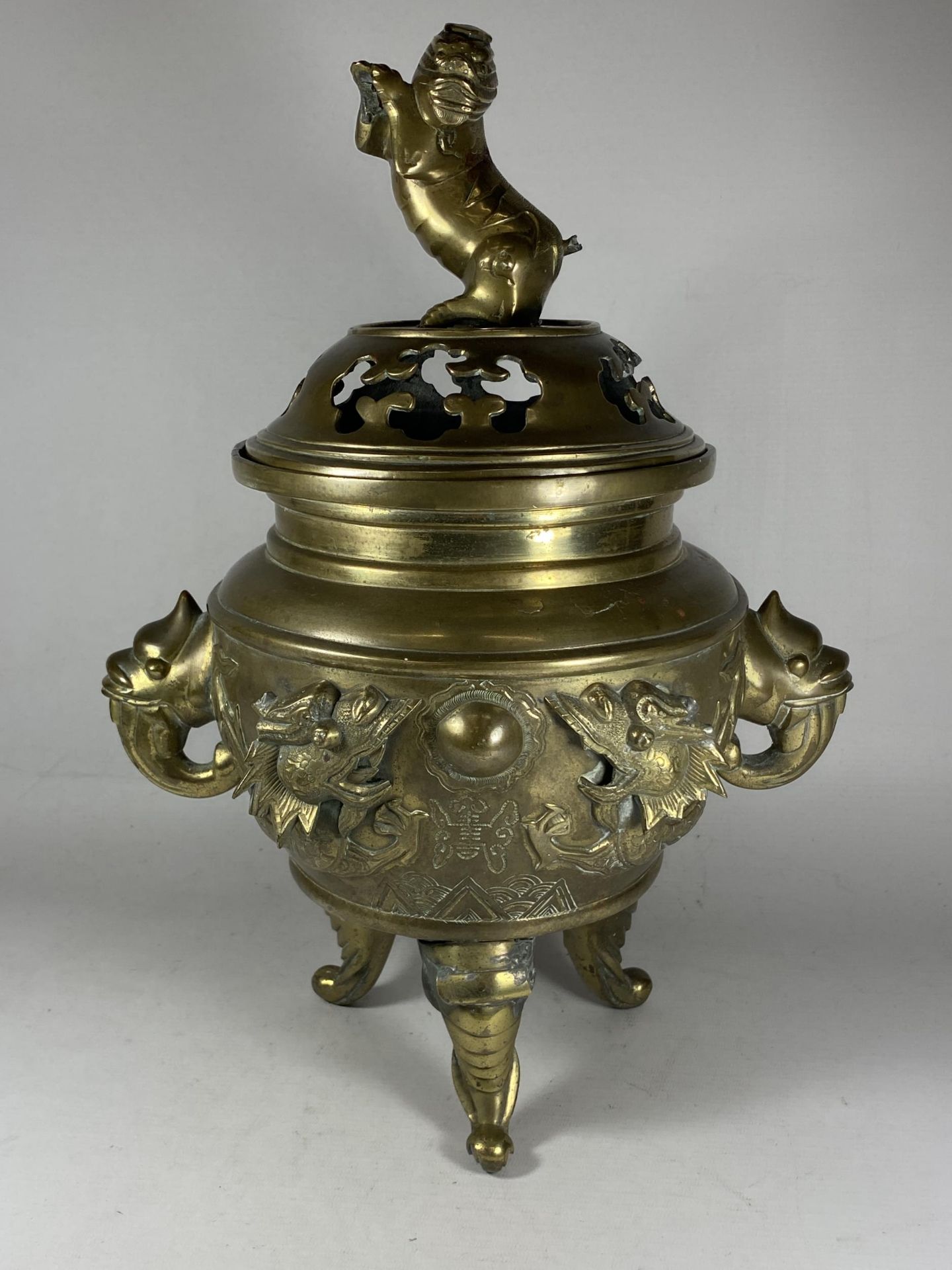 A LARGE CHINESE TWIN HANDLED BRASS LIDDED TEMPLE JAR, WITH DRAGONS CHASING THE FLAMING PEARL