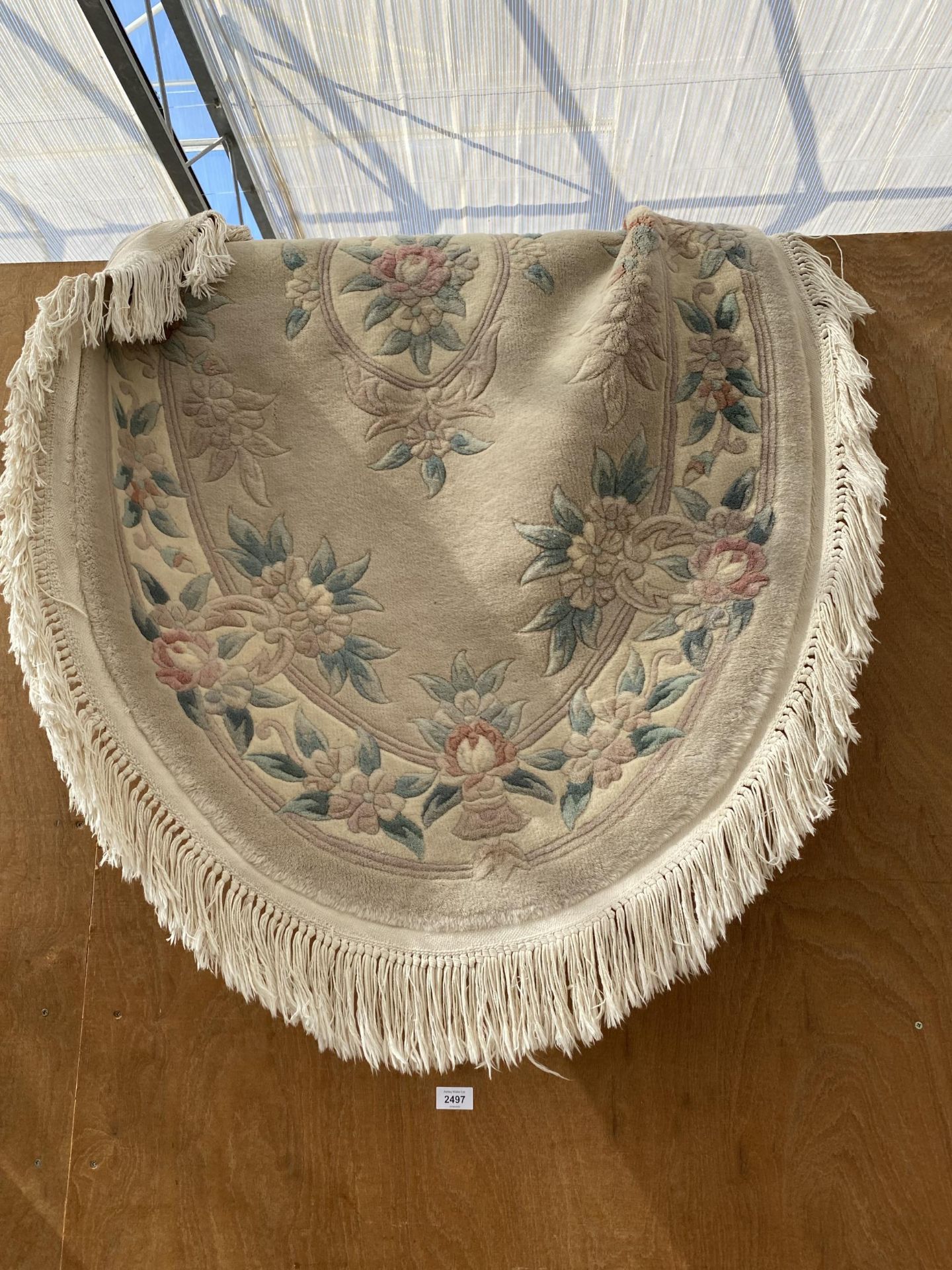 A CREAM PATTERNED OVAL KAYAM FRINGED RUG