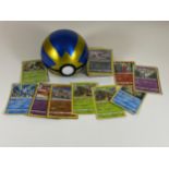 A POKEMON BALL TIN CONTAINING ASSORTED POKEMON CARDS, HOLOS, RARES ETC