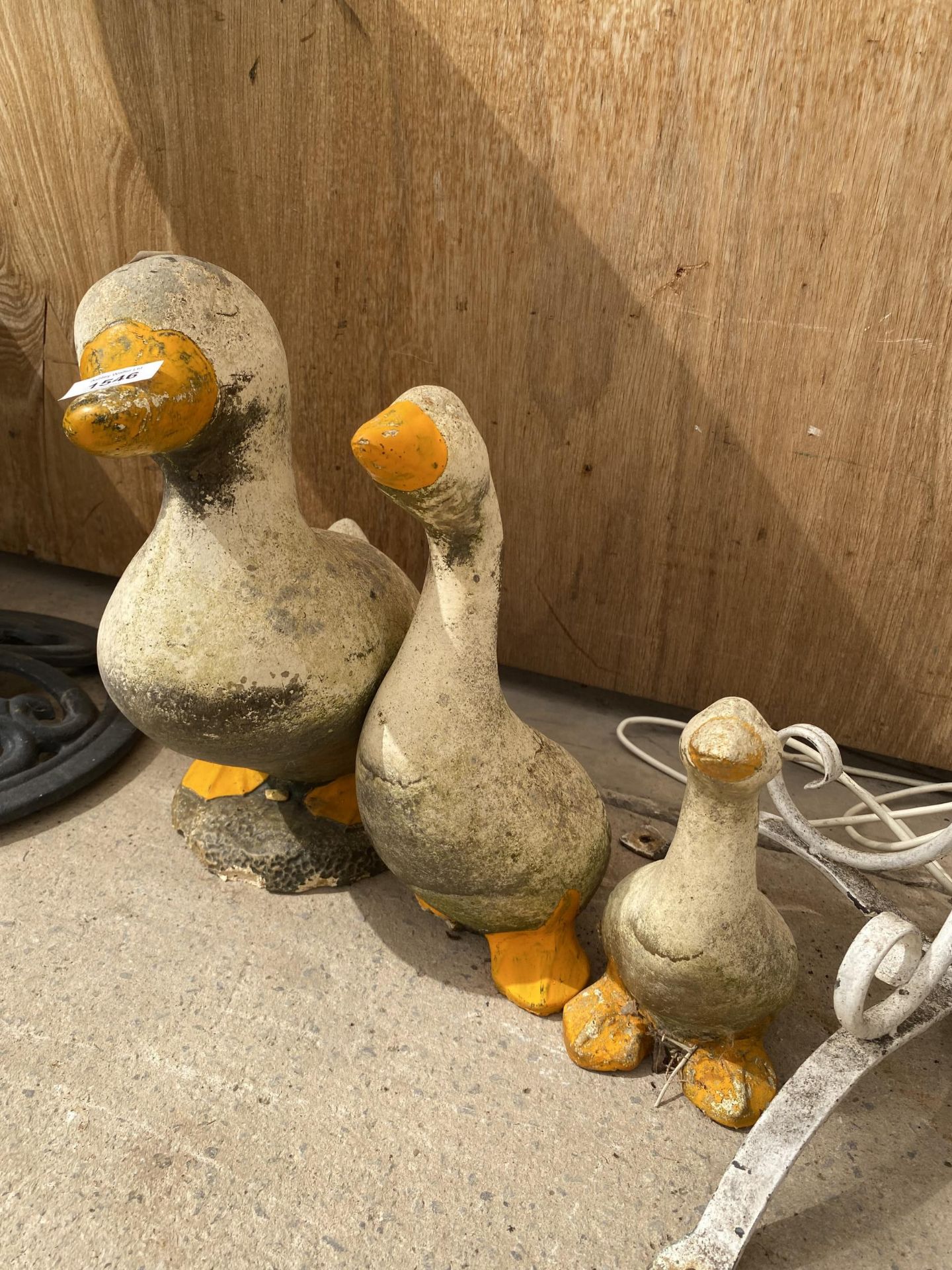 THREE GRADUATED PAINTED RECONSTITUTED STONE DUCK FIGURES