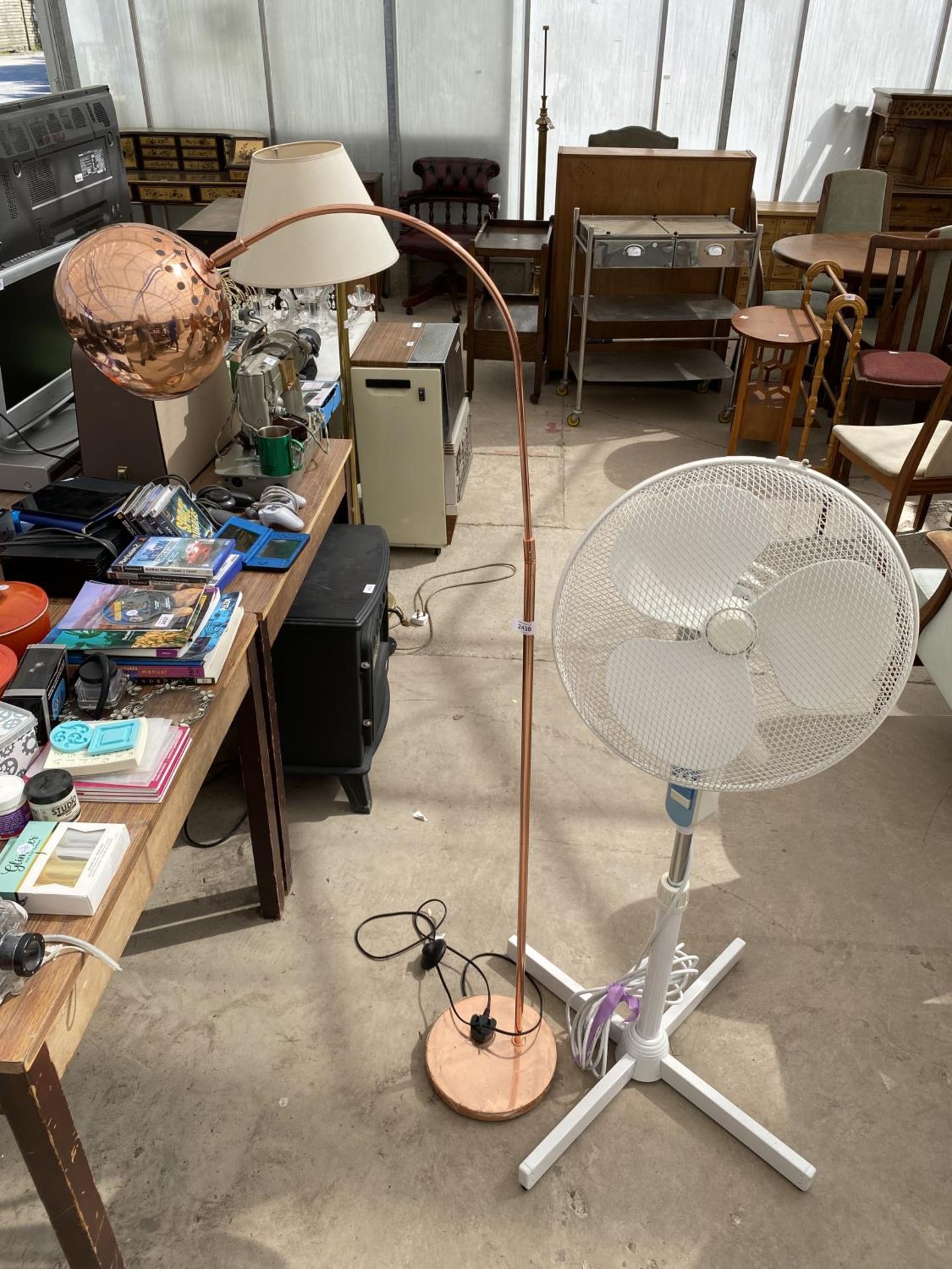 A TALL FAN AND A METAL STANDARD LAMP