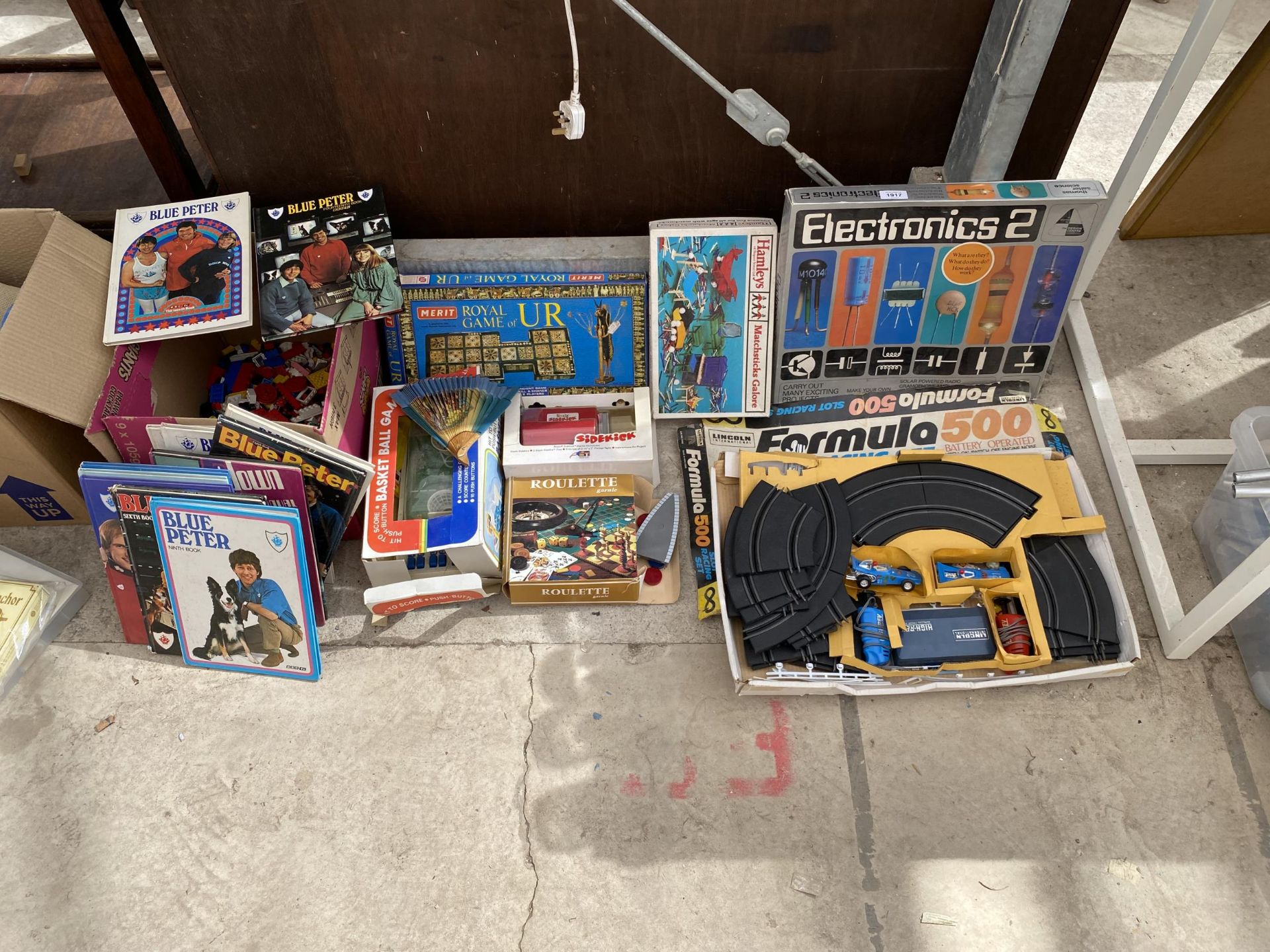 AN ASSORTMENT OF CHILDRENS ITEMS TO INCLUDE LEGO AND BLUE PETER ANNUALS ETC