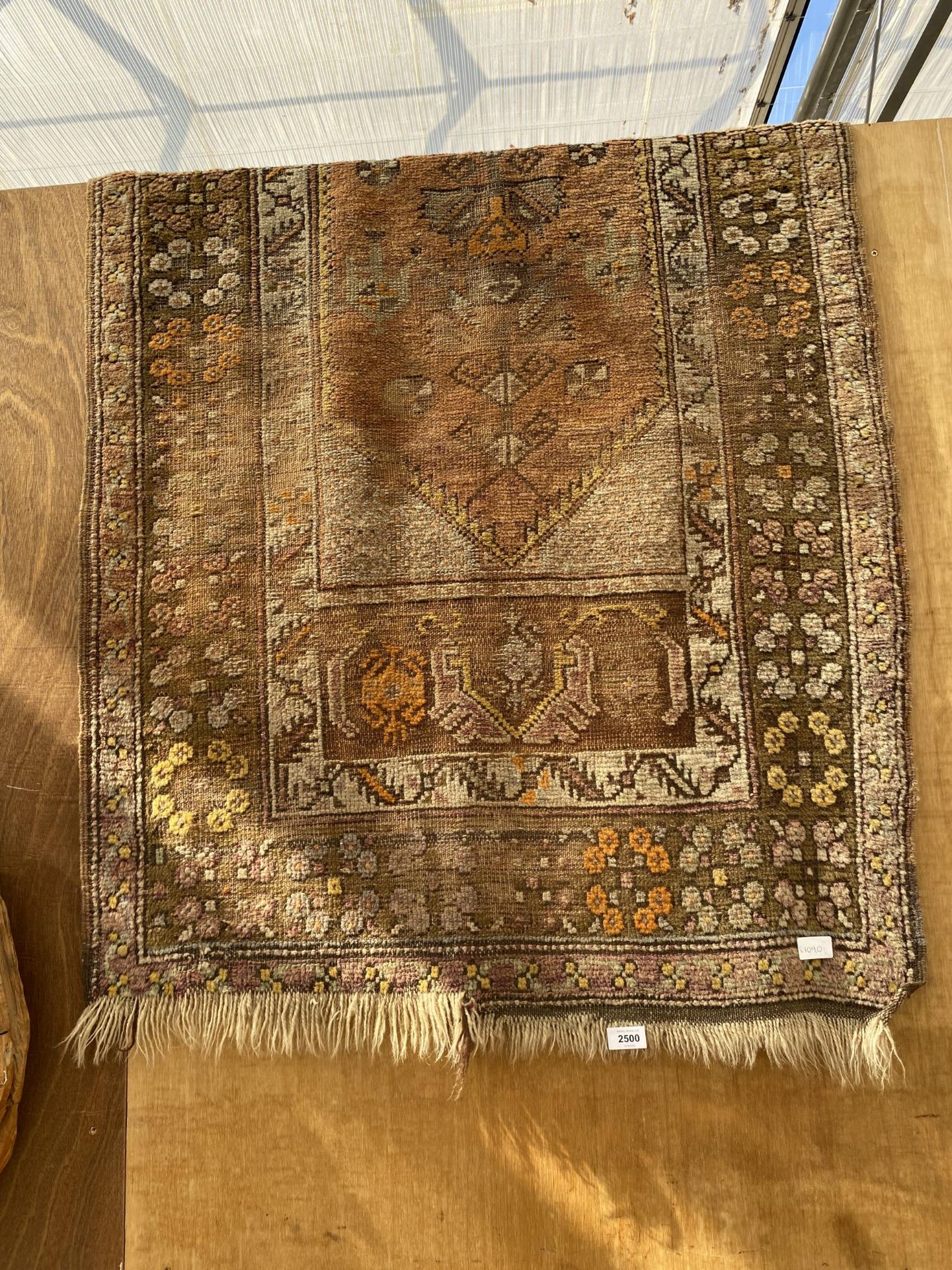 A VINTAGE PATTERNED FRINGED RUG